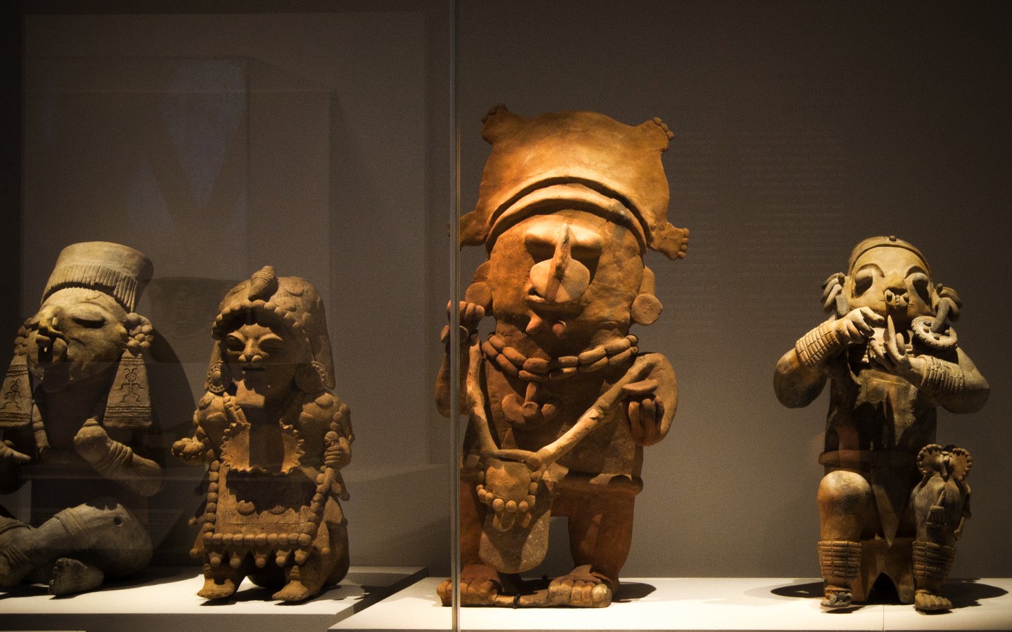 Exhibición de figuras de cerámica precolombina en vitrinas iluminadas del Museo MAAC en Guayaquil, Ecuador