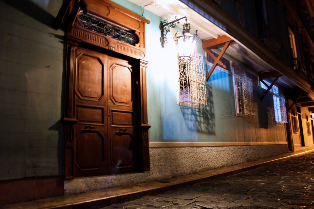 Calle empedrada del barrio Las Peñas de noche con casas coloniales coloridas y talleres de arte en Guayaquil.