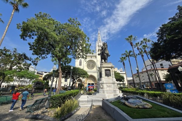 Fachada frontal neogótica de la Catedral Metropolitana de Guayaquil con el monumento ecuestre a Simón Bolívar en el Parque Seminario