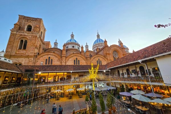 Patio iluminado del Seminario San Luis con vista a las cúpulas azules de la Catedral de Cuenca, Ecuador, de noche